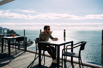 man enjoying at sea view from cafe