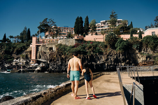 father and daughter holding hands on the ocean beach
