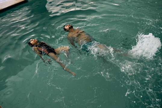 father and daughter in indoor swimming pool