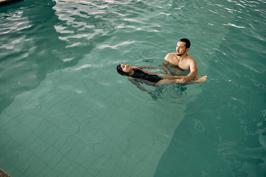 father and daughter in indoor swimming pool