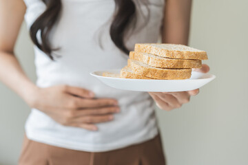 Gluten allergy, asian young woman hand holding, refusing to eat white bread slice on plate in...
