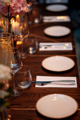 Wedding table setting with plates and cutlery on wooden table