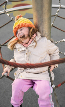 Happy girl playing at an outdoor playground, spring time