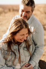 Fototapeta premium A woman laughs as her partner smiles warmly behind her in the sunlight