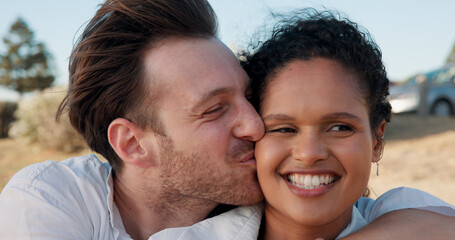 Fototapeta premium Kiss, love and smile with couple at beach for travel vacation, bonding and romantic date. Happiness, summer holiday and marriage anniversary with man and woman outdoors for relax, adventure and hug