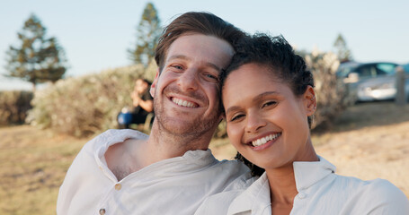 Fototapeta premium Love, interracial couple and smile in portrait outdoor for romantic date, relationship support and weekend break. Happy, people and relax in nature for travel holiday, trust or commitment in marriage