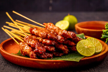 Traditional Grilled, Satay Chicken Skewers Garnished With Fresh Lime Slices on a Bamboo Plate