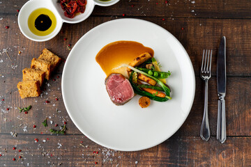 Filet mignon served with vegetables and sauces at a fine dining restaurant