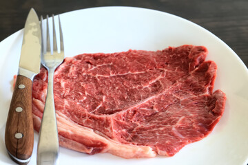 a piece of raw meat, steak on a plate, beef