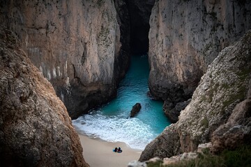 Obraz premium Secluded Cove Beach Aerial View Turquoise Water Rocky Cliffs