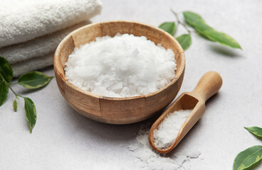 Magnesium flakes in wooden bowl with scoop for spa treatment