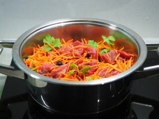 Ready to cook chopped meat in a pan with grated carrots and prunes and herbs and spices. Cooking lunch and dinner from marbled beef