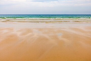 Sand beach with sea waves and a beautiful view to the horizon