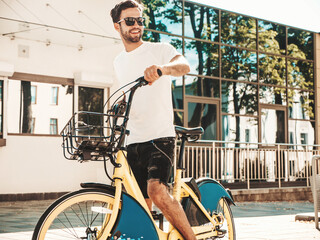 Portrait of handsome smiling stylish hipster lambersexual model.Man dressed in white T-shirt....
