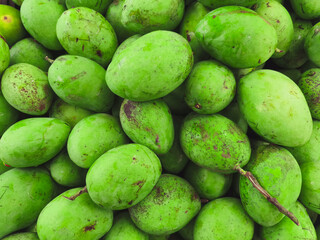 Close-up of a pile of bright green mangoes, a tropical fruit known for its sweet, slightly acidic flavor and numerous health benefits