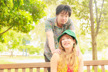 Fototapeta premium ベンチに座る彼女を後ろから抱きしめる彼氏