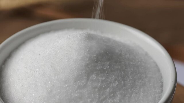 Pour sugar into a white bowl.