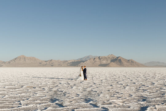Bride and Groom Lovingly looking at each other in a vast salt flat