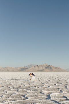 Bride and Groom Dip Kissing in a beautiful salt flat & mountain scene