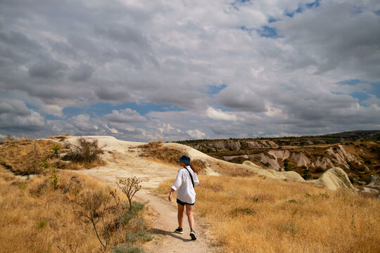 Woman walking on a hill under cloudy skies in Cappadocia
