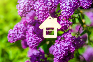 The symbol of the house among the branches of the pink lilac

