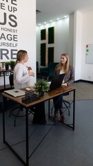 Business meeting between two women in a modern office space discussing project details and strategies in a collaborative environment