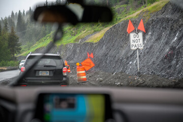 DO NOT PASS and LOOSE GRAVEL road signs along the mountain road. Landslide disaster on the...