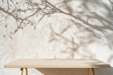 A simple wooden table casting delicate shadows on a textured wall.