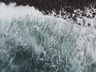 Aerial View of Waves Crashing on Rocky Shore