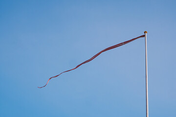 Wind flag flying in the wind on blue sky. flag under blue sky
