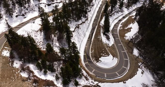 aerial top view of winding road in the snowy mountain forest