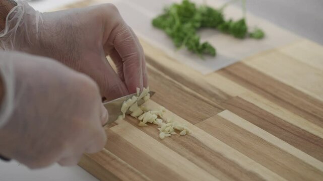 Slicing fresh garlic on a wooden cutting board