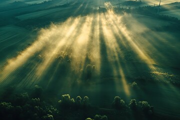 Aerial image of sunlight piercing through morning fog over landscape