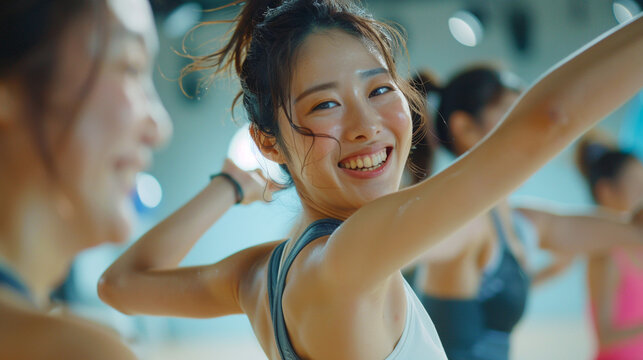 A woman happily dancing in a dance class at a gym studio.