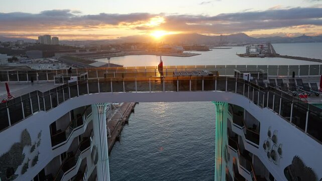 A stunning sunrise over Marseille&rsquo;s port, viewed from the deck of a luxury cruise ship. The golden light reflects on the water and ship&rsquo;s structure, highlighting the design and coastal scenery
