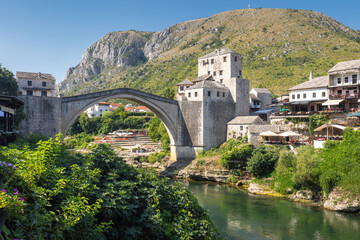 The Stari Most bridge, old bridge on Neretva river in Mostar town, Bosnia and Herzegovina, Europe. Picturesque stone bridge crossing a river with historic buildings in the background. © Viliam