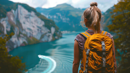 Fototapeta premium Woman with yellow backpack overlooking turquoise lake in steep canyon 