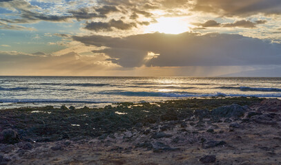 Obraz premium Sunset over rocky ocean shore
