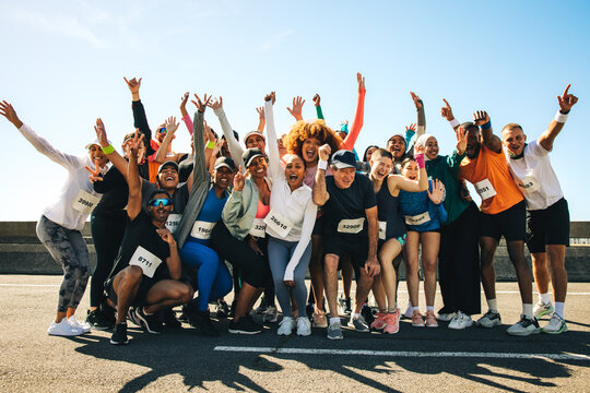 Group of diverse runners celebrating after a community event - Powered by Adobe