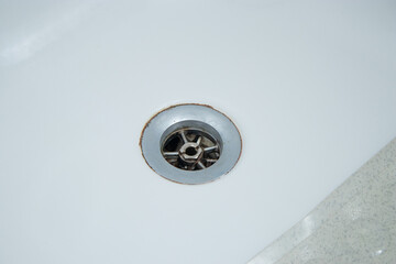 Close up of bathtub dirty metal drain hole with hair and limescale 