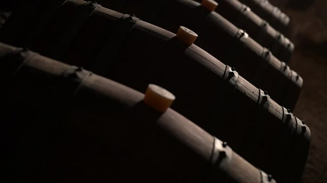 Aged wooden barrels with a wine in a former stone quarry, row of wine barrels at a vintage winery, Wine preparation and fermenting process, High quality 4k footage