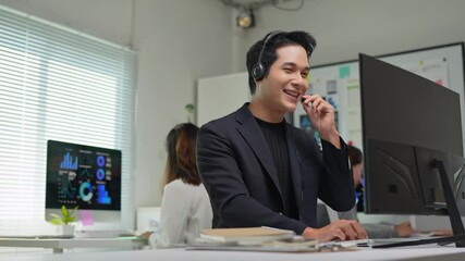 Asian telemarketer working on computer in office - Powered by Adobe