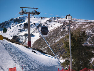 Obraz premium Gondolas that go to the top of the ski resort so that skiers and snowboarders can start the descent of the slope. Concept snow, sport, resort, winter.