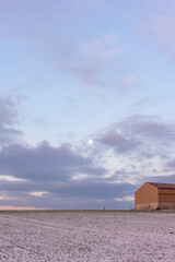 French Farm Barn in Snow Field at Sunrise or Sunset