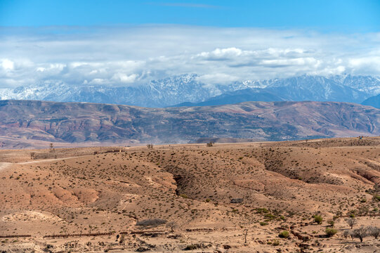 Panoramic view of Agafay village in the Moroccan desert with distant snow-capped mountains