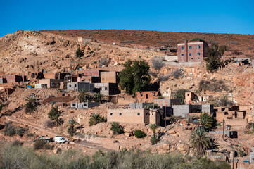 Exploring traditional settlements in the Atlas Mountains of Morocco under a clear blue sky