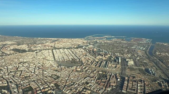 An elevated aerial view of Valencia city and harbor, with the Mditerranean Sea at the back. Splendid sunny day. Taken from an airplane cockpit.