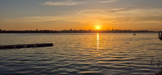 Obraz premium a serene backdrop of a lake reflecting the golden hues of a breathtaking sunset