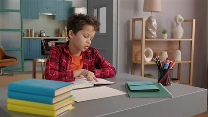 Tired cute teenage African American kid studying with textbook, experiencing difficulties with understanding educational materials and asking for assistance, holding banner with text help.