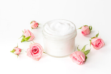 Closeup of pink roses essence skin care cream with flowers and petals